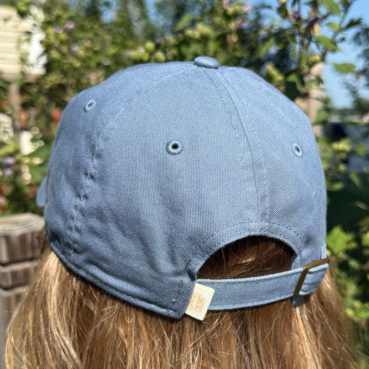 Back of blue jean cotton hat with adjustable strap, worn